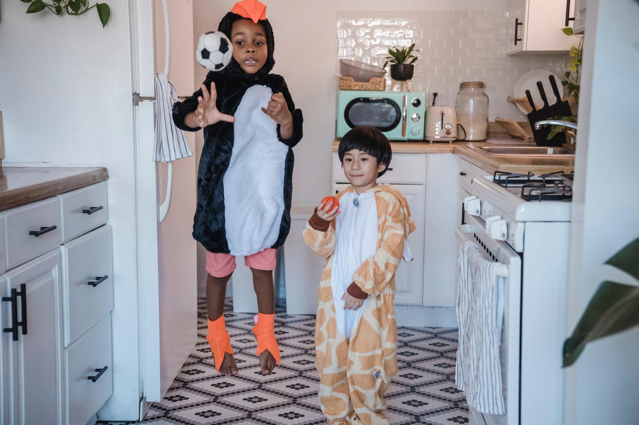 Kids wearing costumes, jumping in the kitchen next to fridge. - via fridge.com