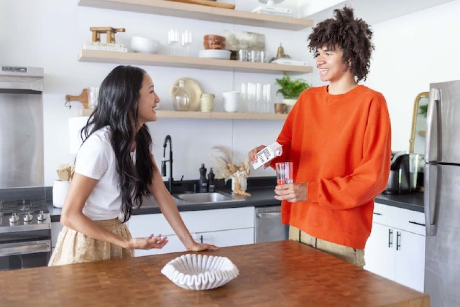 Friends pouring drinks in the kitchen