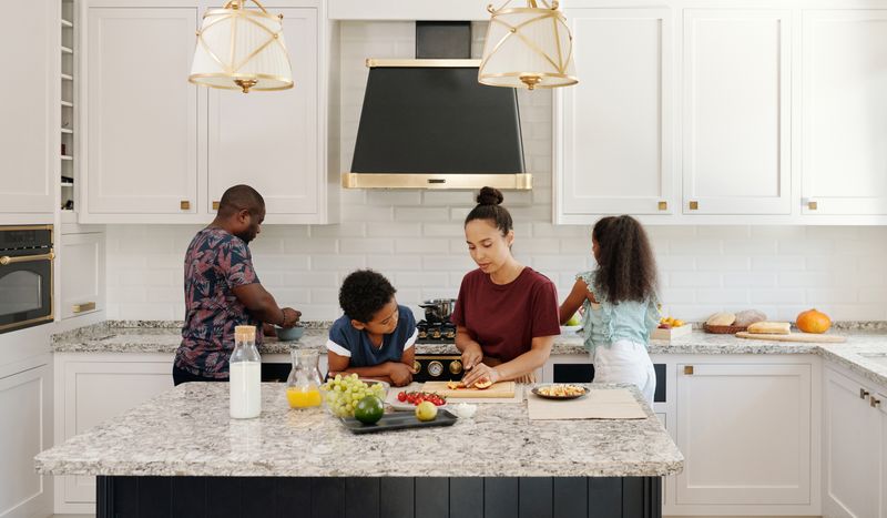 Family preparing a meal around a kitchen island