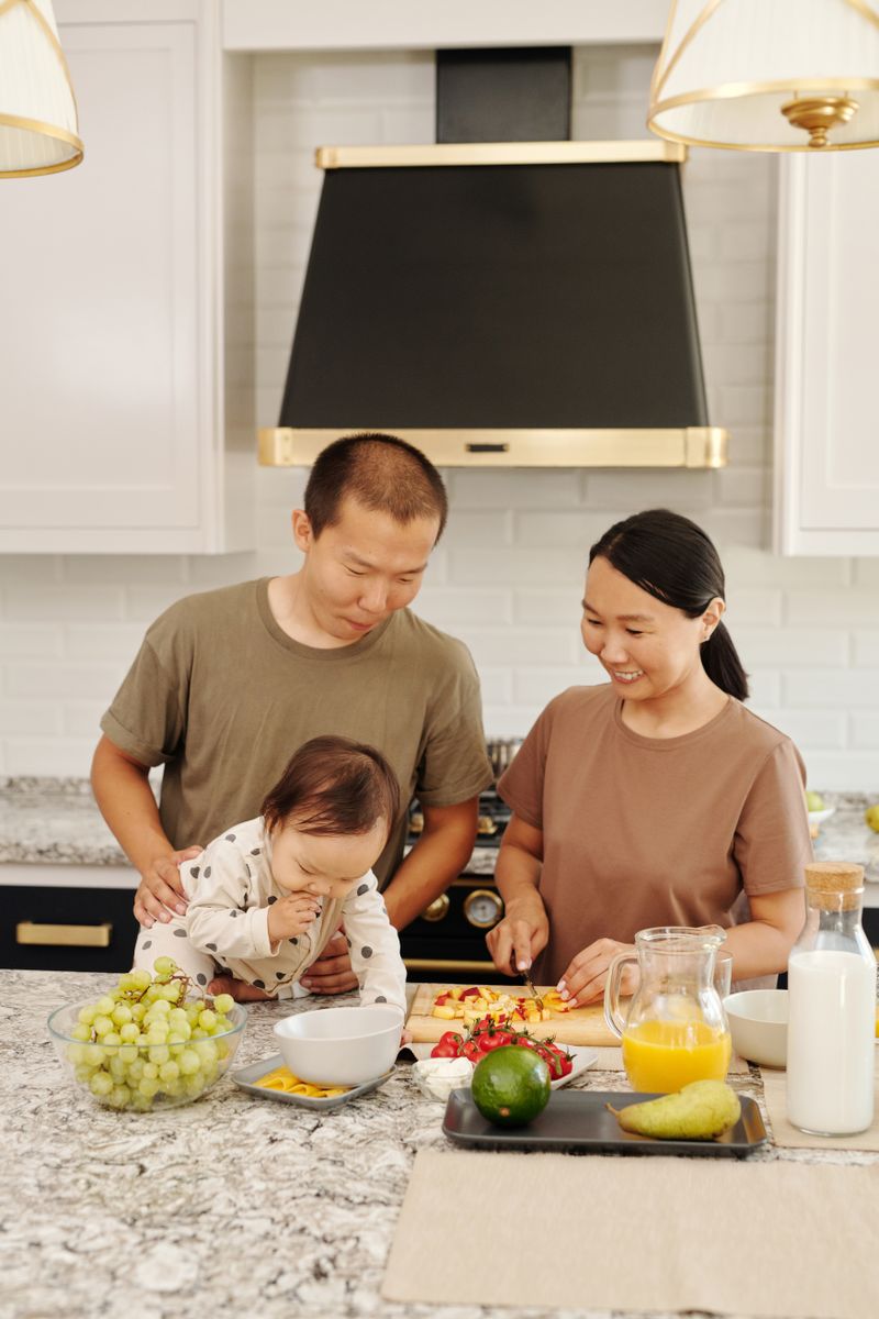 Parents and toddler with fresh food on a kitchen counter