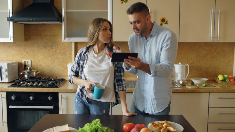 Couple planning together with a tablet at the kitchen counter